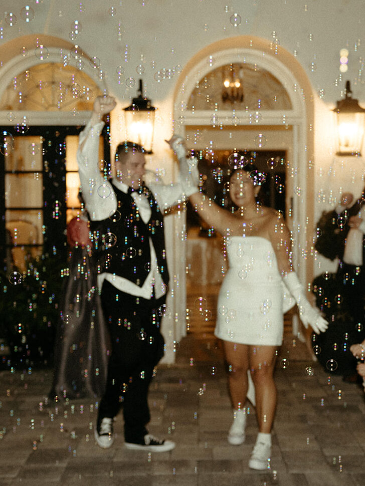 Bride and groom celebrate their nuptials and exit Azalena Manor after their wedding through a cloud of bubbles.